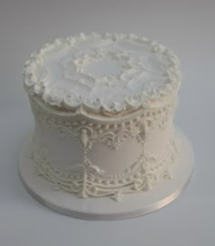 a white wedding cake with intricate designs on top