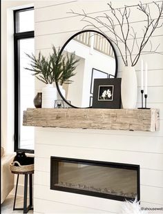 a white fireplace with a mirror and vase on top