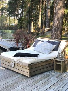 a bed sitting on top of a wooden deck