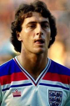 a young man in a soccer uniform looking at the camera with an intense look on his face