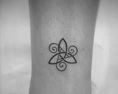 a black and white photo of a small tattoo on the ankle with an intricate design