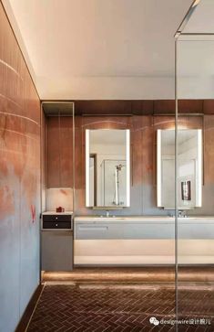 a bathroom with two sinks, mirrors and a large mirror on the wall above it