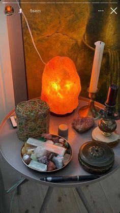 a table topped with lots of different types of items next to a lit candle and some candles