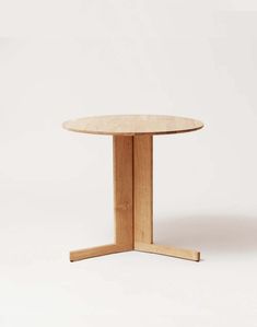 a round wooden table sitting on top of a white floor