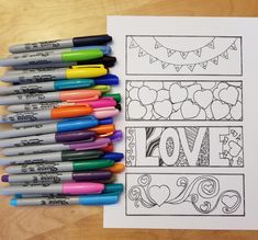 coloring pages with markers and pens sitting on a table next to them are the word love