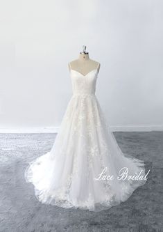 a white wedding dress on a mannequin in front of a white wall with the words lace bridal