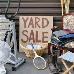 a yard sale sign sitting on top of a chair next to a racquet