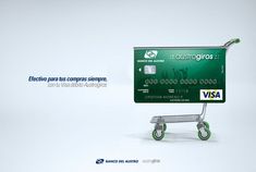 a green credit card sitting on top of a metal cart