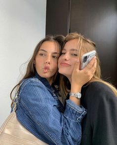 two young women taking a selfie with their cell phone