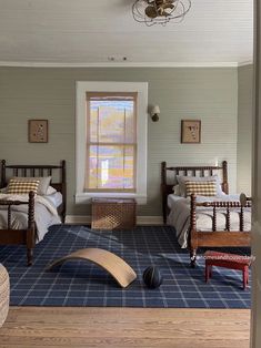 a bedroom with two beds and a rug on the floor in front of it is shown