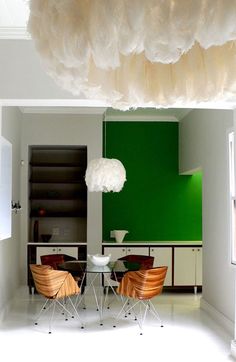 an image of a dining room setting with green walls and white fluffy balls hanging from the ceiling