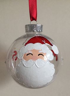 a glass ornament with a santa face on it