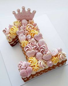 a cake shaped like the letter e with pink and yellow frosting