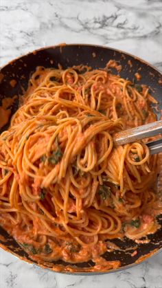 a pan filled with pasta and sauce on top of a table