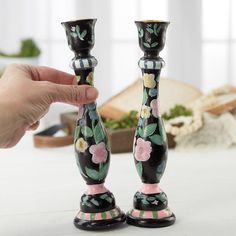 two black and pink candlesticks with flowers on them