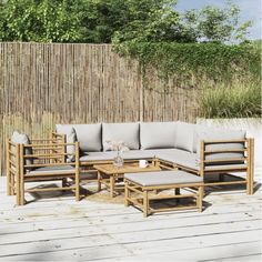 a wooden couch sitting on top of a wooden floor next to a bamboo privacy wall