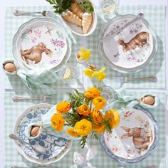 an easter table setting with yellow flowers and bunny plates