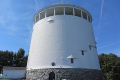 a large white tower sitting on top of a lush green field