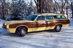 a brown and yellow station wagon parked in the snow