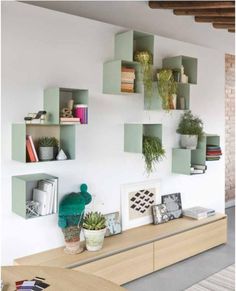 some shelves that have plants on them in the middle of a room with white walls