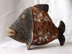 a fish made out of mosaic tiles on a white background