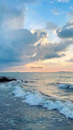 the ocean with waves coming in to shore and a sky filled with clouds above it