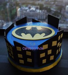 a batman themed cake with the city in the background