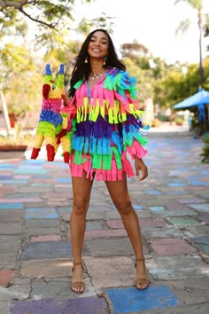 a woman in a colorful dress standing on the sidewalk