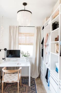 a white desk with a computer on top of it next to a chair and window