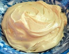 a blue and white bowl filled with yellow frosting