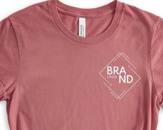 a pink t - shirt with the brand logo on it