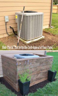 an air conditioner sitting on top of a wooden planter box next to a building