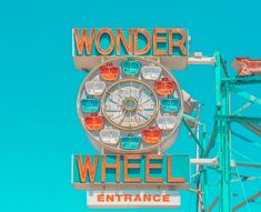 a ferris wheel sign with the word wonder wheel on it's side against a blue sky