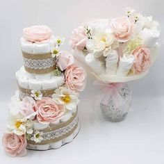 three tiered wedding cake with pink and white flowers on top, sitting next to each other