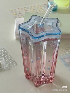 a pink and blue drink sitting on top of a table next to other items in the background