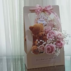 a teddy bear and flowers in a gift bag