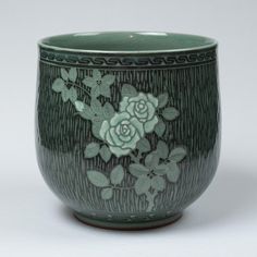 a close up of a vase with flowers on the outside and inside of it's rim