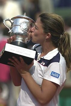 a female tennis player kissing the trophy