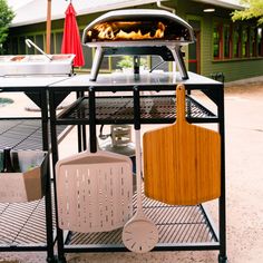 an outdoor grill with cooking utensils on it