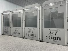 several portable toilets are lined up against the wall