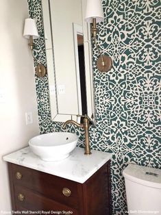 a white sink sitting under a bathroom mirror next to a wooden vanity with a marble counter top