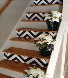 the stairs are decorated with flowers and black and white chevron wallpaper, which is also on the walls