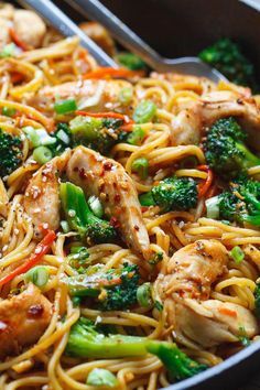 chicken, broccoli and noodles in a pan with tongs on the side