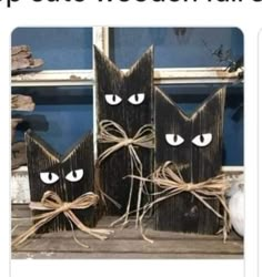 two black wooden cats with eyes tied to each other