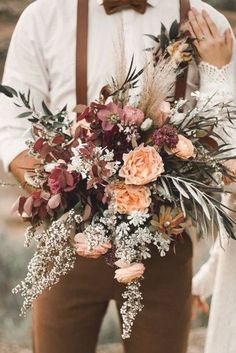 a man and woman standing next to each other with flowers in their lapel holders