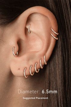 an ear with three different types of piercings on the top and bottom of it