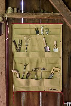 a wall mounted tool rack with tools hanging on it