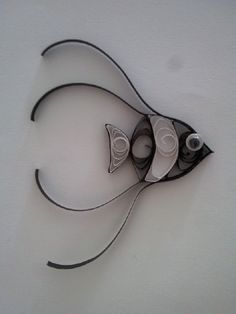 an artistic sculpture made out of black and white paper with spirals in the shape of fish