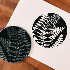 two black and white plates sitting on top of a wooden table next to each other