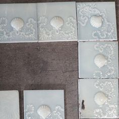 four seashells are arranged on the floor next to each other in white tiles